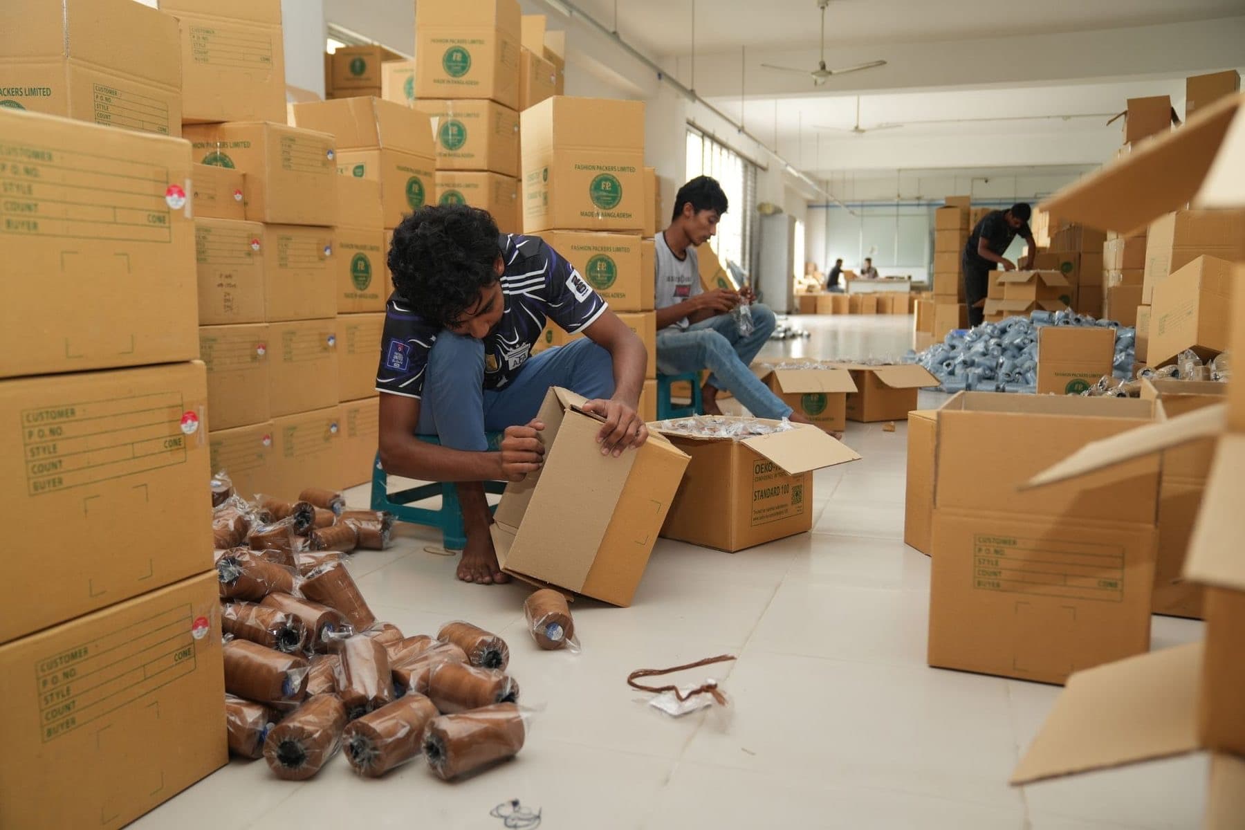 Workers packing goods into cartons